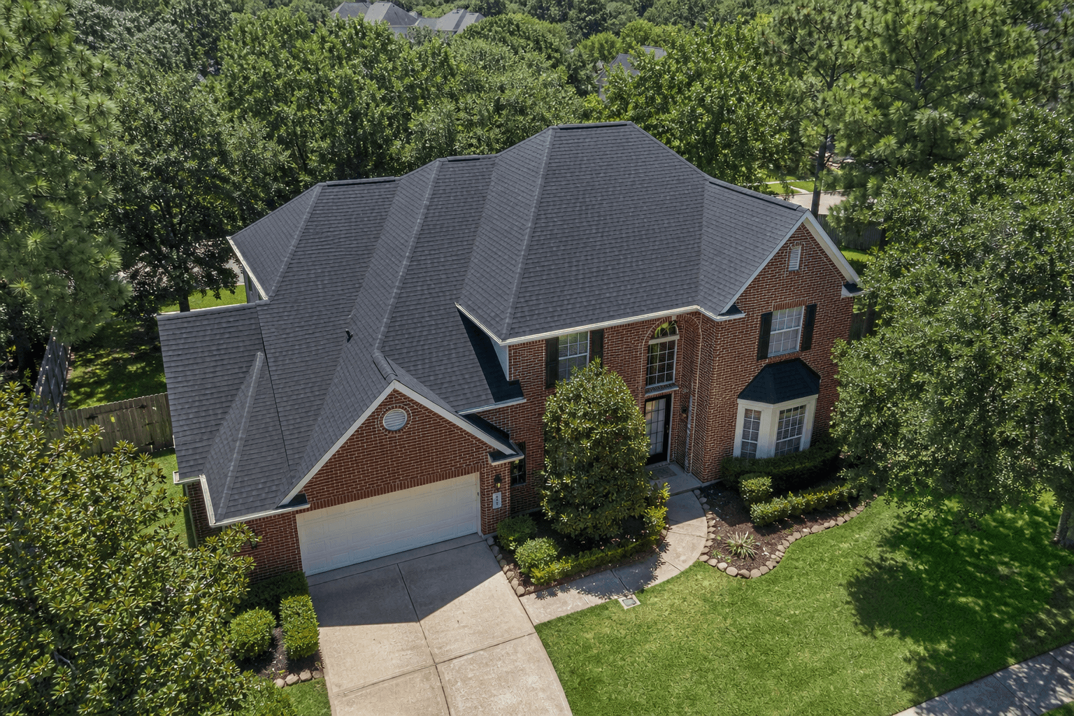 Illustrative example of a suburban Houston home with brand-new GAF Timberline UHDZ charcoal asphalt shingle roof installed by Texas Premier Contractors