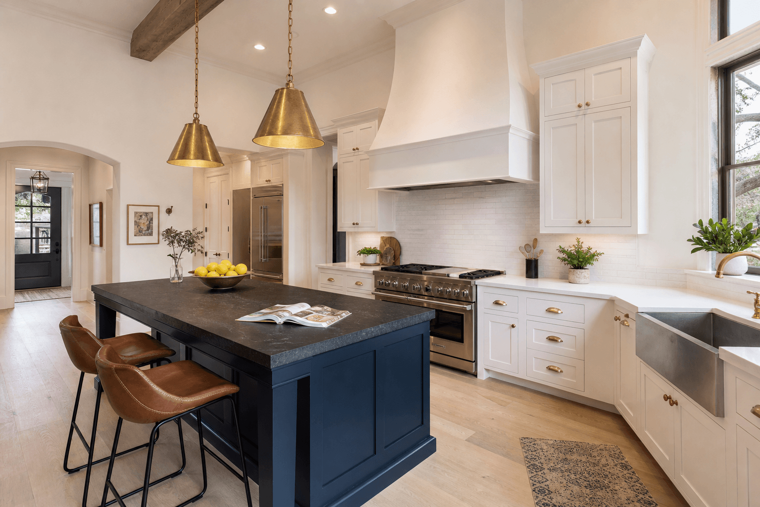 Beautifully renovated transitional-style kitchen with white cabinets and navy island remodeled by Texas Premier Contractors in Greater Houston